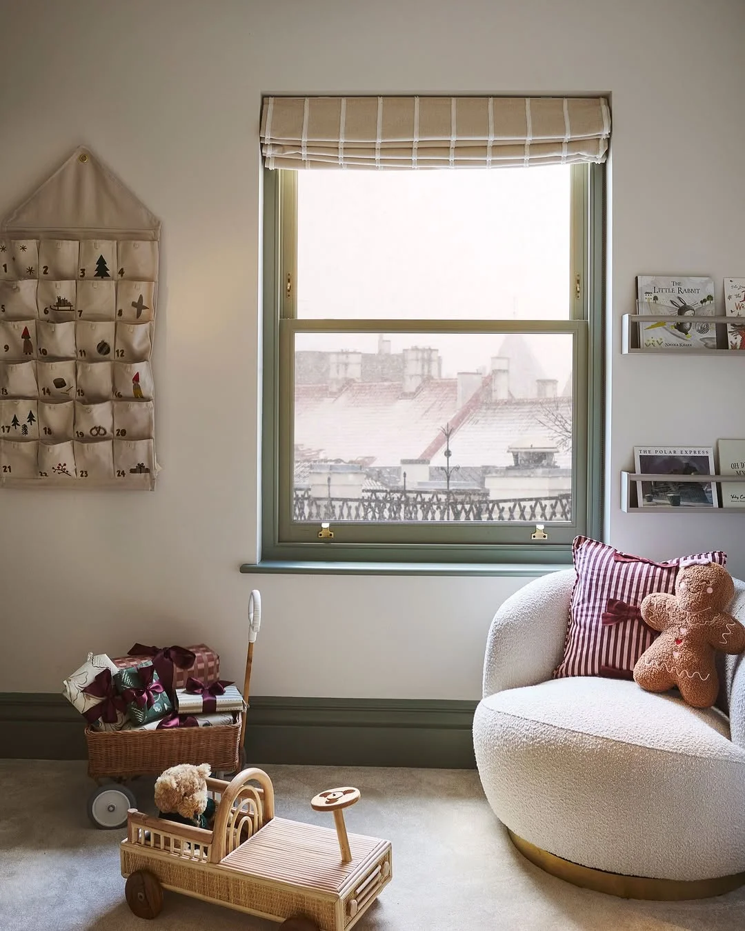 A child's bedroom corner with a fabric advent calendar hanging on the wall beside a window
